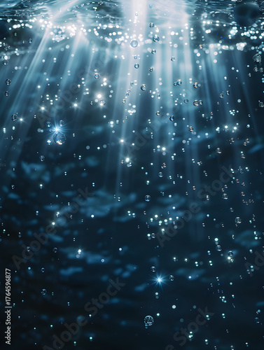 Stunning underwater shot with shimmering light rays piercing through the surface, illuminating countless tiny air bubbles and sparkling particles suspended in the deep blue ocean