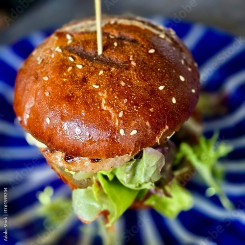 Close-up of gourmet burger with lettuce and sesame bun