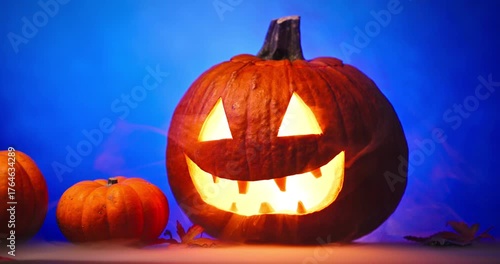 Creepy Halloween Pumpkin with Glowing Red Eyes and Smoke on blue background
