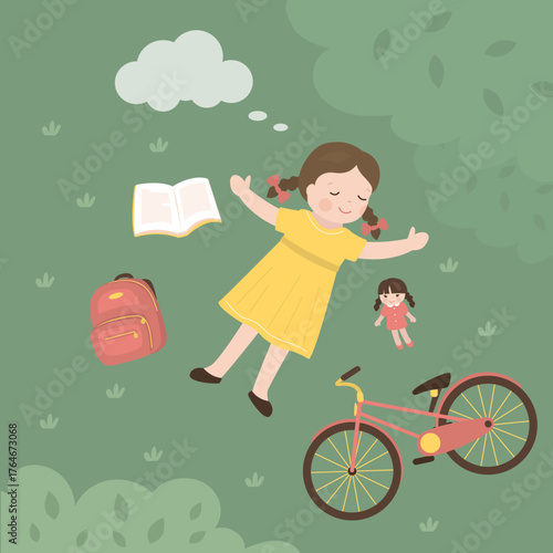 Top view of cute girl lying down on green lawn. Little kid lying on grass dreamily. Various items near kid - bicycle, doll, backpack and book.
