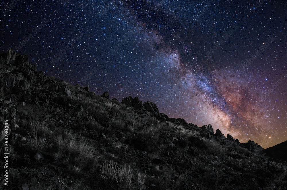 Naklejka premium Black and white mountain pattern set against a vibrant star-filled night sky