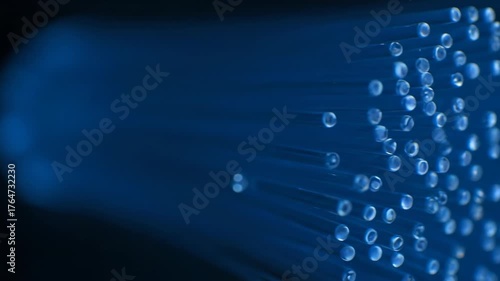 Fiber Optic Cables: Abstract shot of fiber optic cables illuminated in blue, symbolizing high-speed data transmission and modern technology.