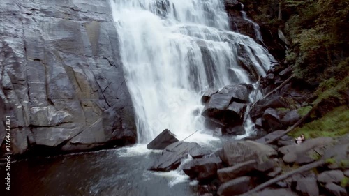 Rising drone shot of the massive waterfall, Rainbow Falls, in the Blue Ridge Mountains of North Carolina.