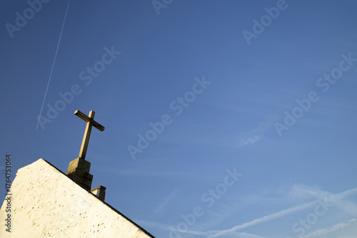 A stone Christian cross, with a blue sky in the background...4