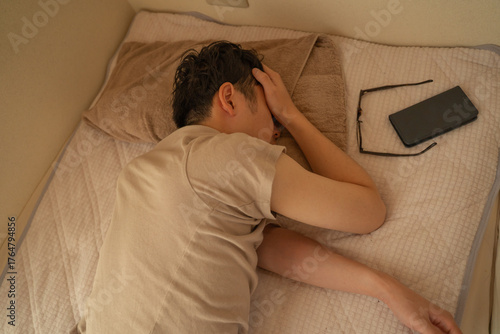 頭痛で眠る男性
