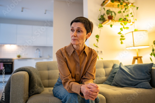 Bild auf Leinwand Upset mature woman with crossed arms wait on couch, tense concern