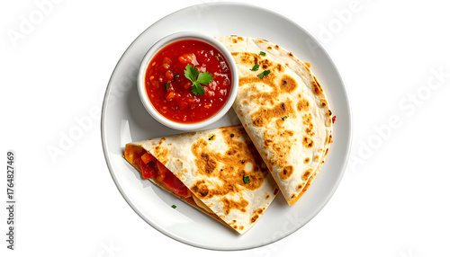Overhead view of a white plate holding two folded grilled flatbreads with red salsa