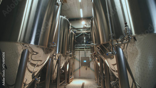 Foto Shiny stainless steel fermentation tanks and conical vats standing in a modern b