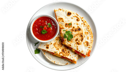 Overhead view Two folded quesadillas, salsa, and cilantro on a white plate against black