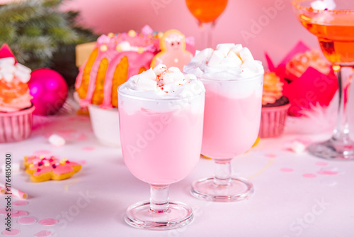 Pink Christmas milkshake. Traditional fruit cake and cupcakes on the background. Winter festive table. Holiday celebrate concept.