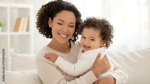Smiling mother holding happy toddler at home