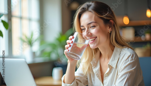 A female manager drinks clean water from a glass in the office