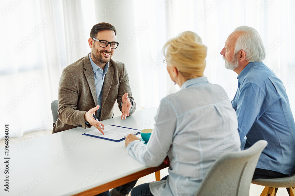 Obraz premium Senior couple having a meeting with an agent, businessman, salesperson or doctor in his office