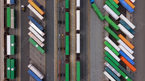 Aerial top-down view of cargo trucks and trains at intermodal terminal in October 7, 2025