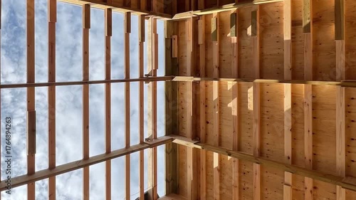 A low angle view of the roof rafters of a barn under construction