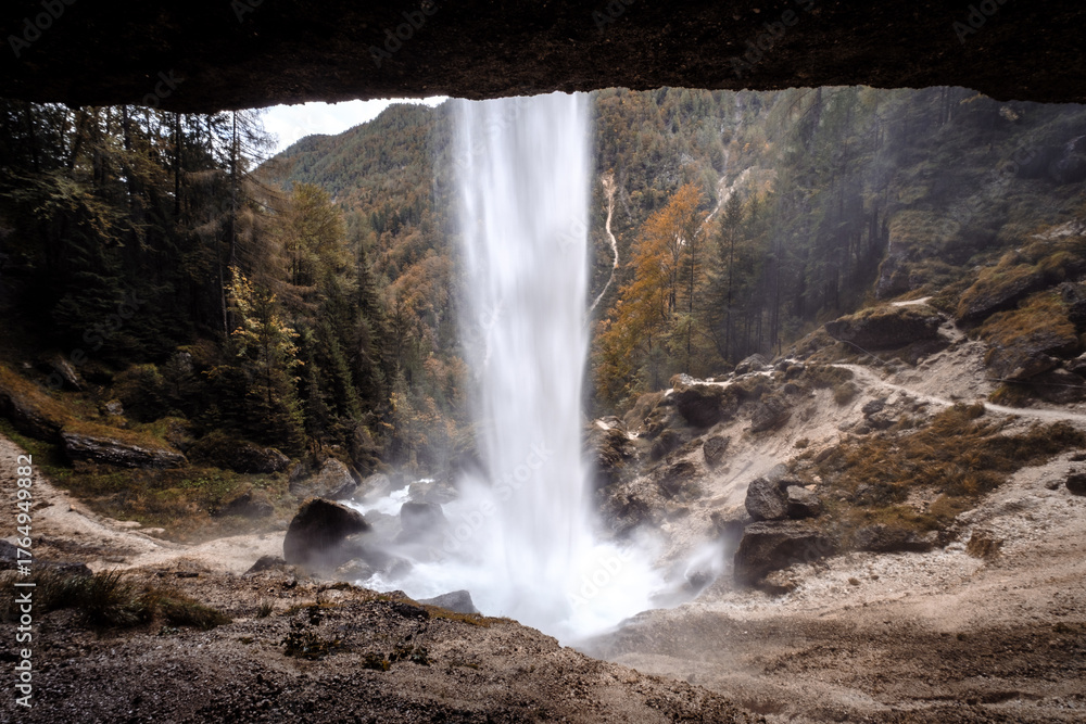 Obraz premium View of a waterfall from a cave entrance.