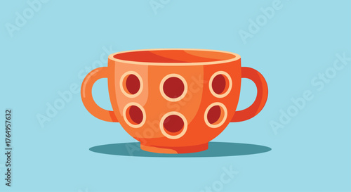 An orange cup with polka dots sits on a table.