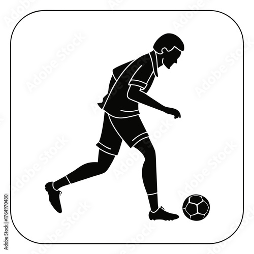 Soccer player dribbling the ball in silhouette