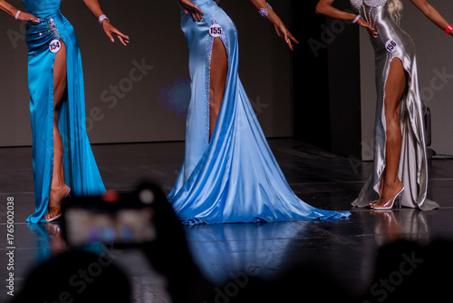 Obraz na plátně Contestants walk gracefully in stunning gowns during a fashion show