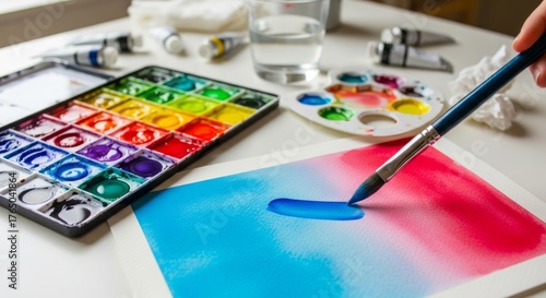 Watercolor painting in progress with colorful paint palette and brush