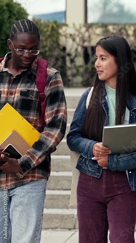 African and Asian University student friends walking and talking together on campus