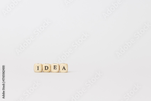 Wooden blocks spelling out the word idea on a minimalistic background, symbolizing creativity and inspiration in a modern workspace. copy space