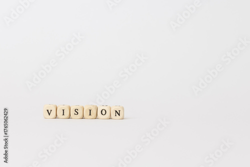 Wooden blocks spelling vision on a minimalistic background, emphasizing clarity and focus in personal and professional development. copy space