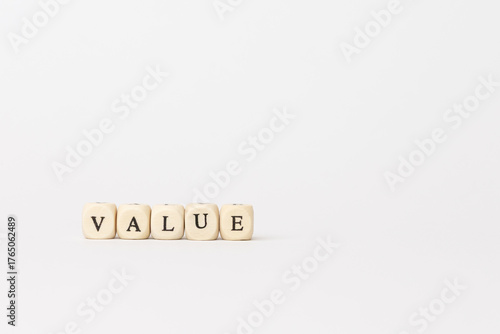 Wooden blocks spelling out the word value on a clean white background, symbolizing finance and technology concepts in a minimalist style. copy space