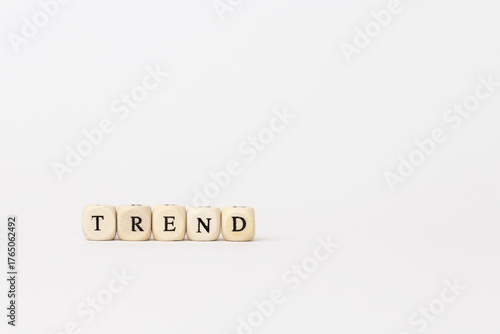 Trend letters displayed on wooden cubes against a minimalistic background, representing modern finance and technology concepts with copy space. copy space