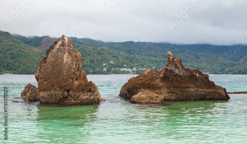Canvas Print Battered rock formations emerge from calm turquoise sea