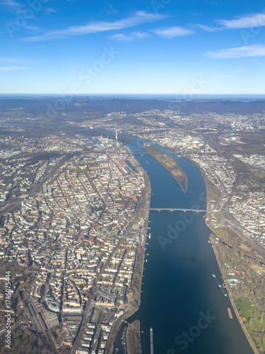 Wide-angle aerial view of Mainz and the Rhine River with city structures, bridges, and harbors visible under a clear blue sky