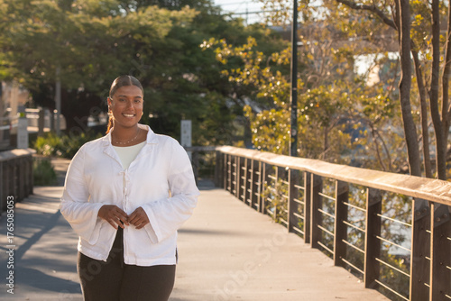 young indian woman walking on a boardwalk next to the Brisbane River