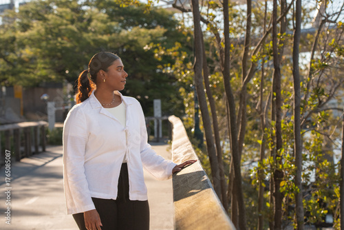 young indian woman walking on a boardwalk next to the Brisbane River