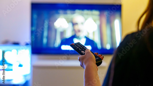 Person using remote to browse streaming apps on smart tv