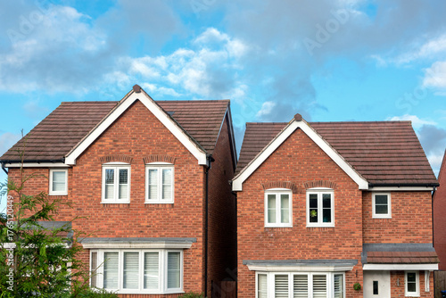 UK modern family houses - Real estate and mortgage issues. Red brick detached new build houses in common English new development neighbourhood. Residential buildings in suburban street. Housing market
