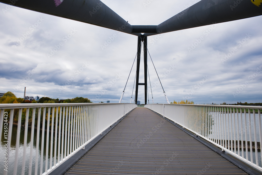 Fototapeta premium Cloudy day view from a modern bridge over a river in a city