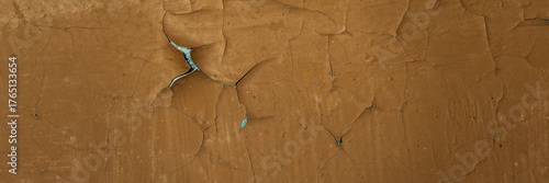 Peeling paint on the wall. Panorama of a concrete wall with old cracked flaking paint. Weathered rough painted surface with patterns of cracks and peeling. Wide panoramic texture for design background