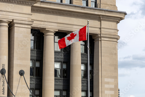 Canadian national flag waving near the Senate of Canada building.