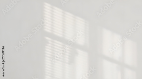 Soft sunlight casting geometric shadows on a white wall
