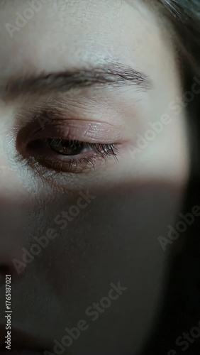 Close-Up of a Woman's Face with Shadow and Soft Light Highlighting Natural Beauty and Emotions