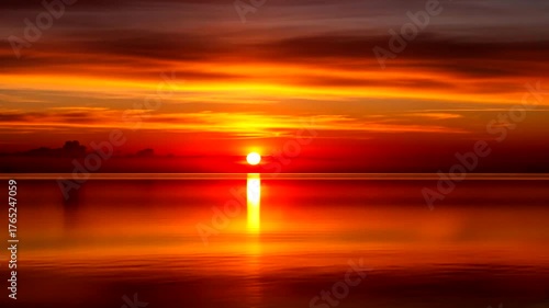 Vibrant sunset over calm waters, reflecting warm hues in the sky and serene landscape