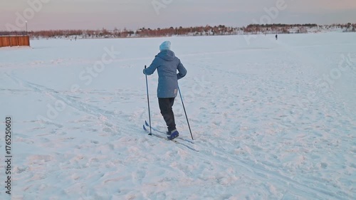 Back view of a woman falling while cross-country skiing. Sports Injuries, Sprains, Fractures