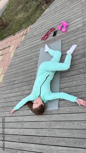 A young woman practices yoga outdoors. 