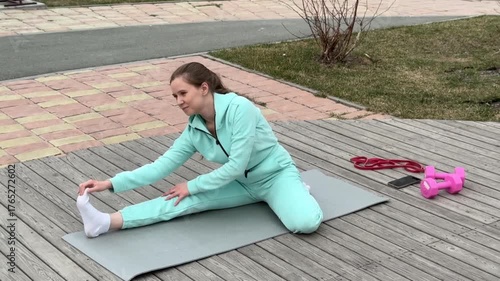 A young woman practices yoga outdoors. 