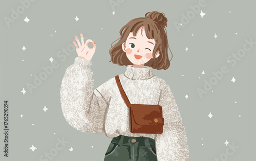 따뜻한 스웨터와 크로스백을 멘 귀여운 소녀가 OK 사인을 하며 윙크하는 모습