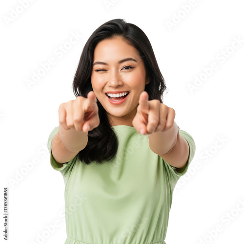 Portrait of a cheerful young Asian woman standing against a white background, smiling brightly and winking playfully while pointing both index fingers toward the camera. She wears a light green.