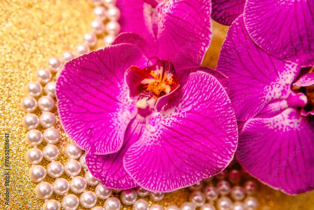 Fototapeta premium purple Orchid and pearl necklace on a shiny gold background 
