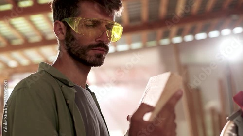 A man wearing safety glasses is reading a book