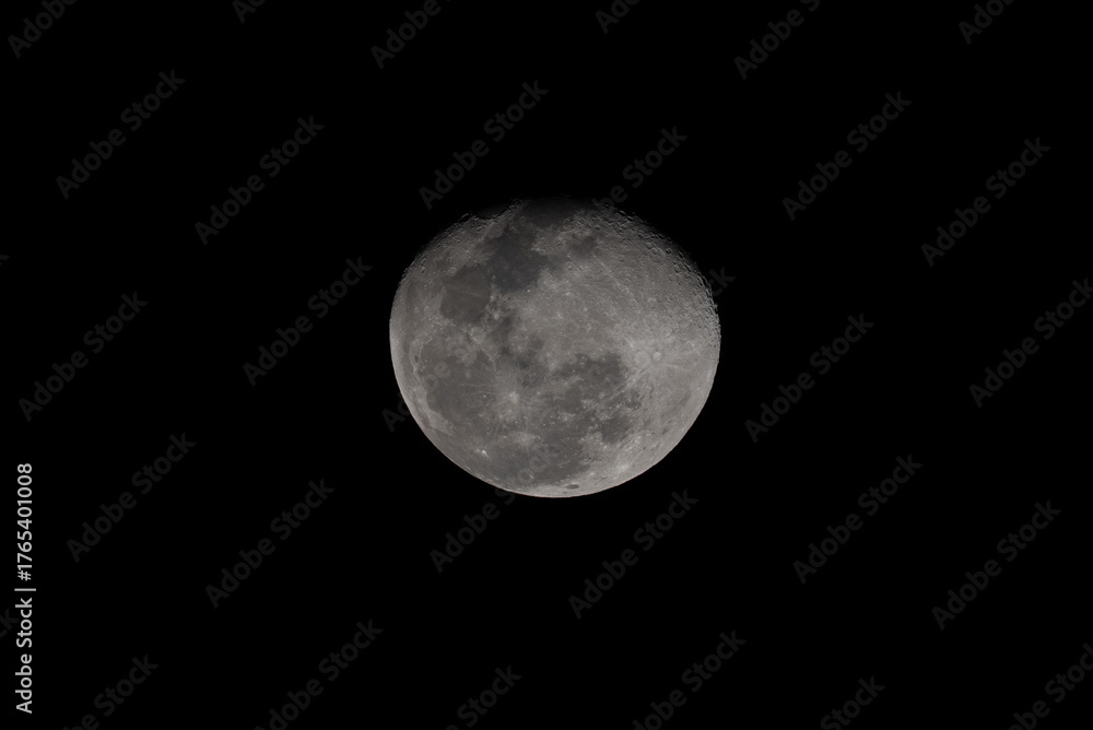 Obraz premium Close-up photo of the bright moon at night, showing detailed craters and lunar surface texture against a dark black sky. Perfect for astronomy, science, and nature themes.