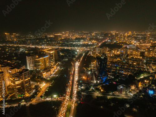 Wallpaper Mural Aerial view of the Golf Course Extension Road, a ribbon of light cutting through the dark cityscape, illuminated by the vibrant glow of Gurugram, Haryana, India. Torontodigital.ca